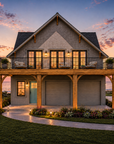Front exterior view of Tilbury Lane, a 1,585 sq ft elevated coastal carriage house plan with shingle siding, timber brackets and a covered balcony beneath a steep 10:12 gable roof.