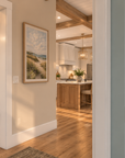 Stair landing in Islabella, with coat hooks and a bench beside the stair and a view through to the kitchen.