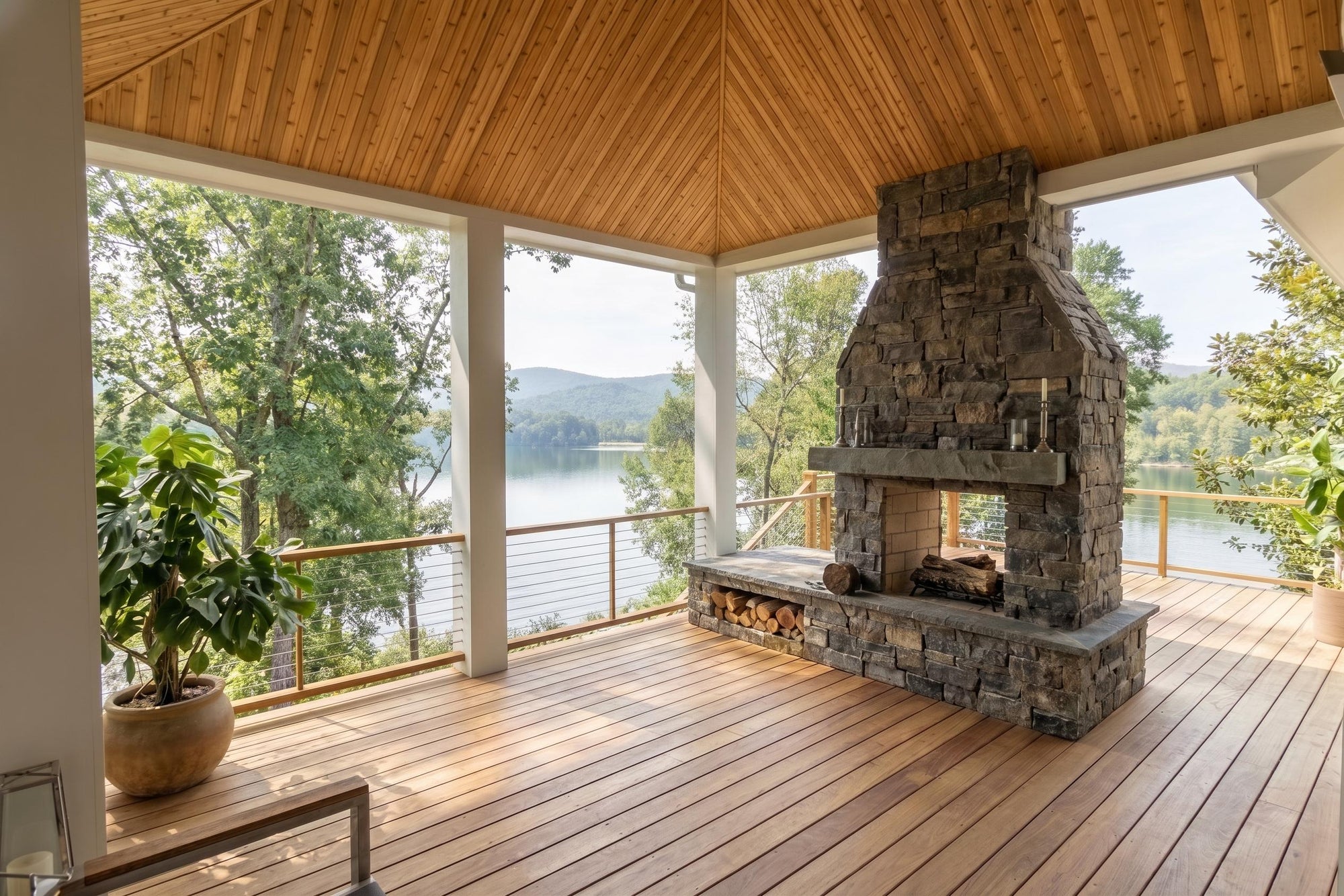 Outdoor deck with stone fireplace and lake view
