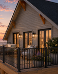 Front deck at Tilbury Lane at dusk, with metal railing, seating and the glass sliders serving the living space and primary suite.