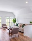 Living room in a built Tilbury Lane, with vaulted ceiling, half-wall stair rail and glass sliders opening onto the 31-foot deck.